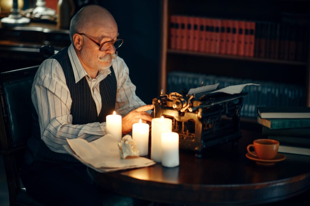 Adult writer on a vintage typewriter writing by candle as an idea for intellectual hobbies